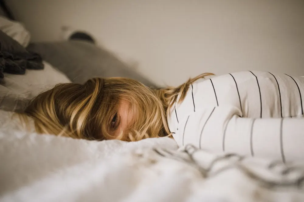 Person waking up in bed from sleep.